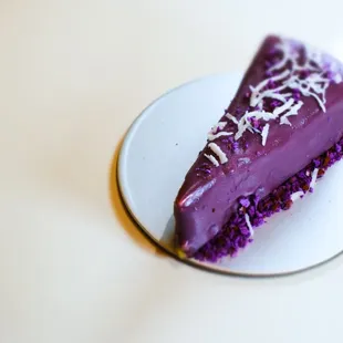 Creamy cheesecake infused with purple yam, adorned with a touch of coconut.