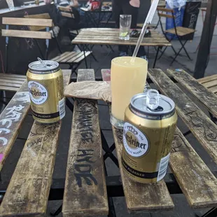 two cans of beer on a wooden table