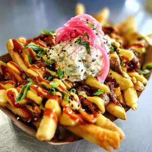 a plate of fries with a pickle on top