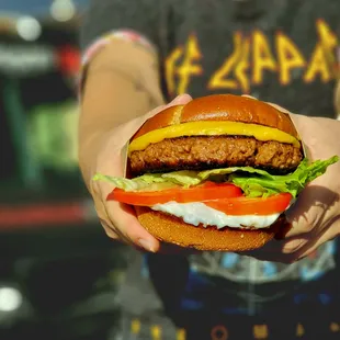 a person holding a hamburger