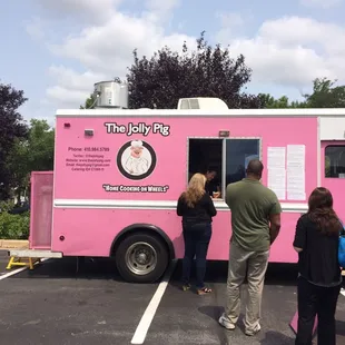 people ordering food from a pink food truck