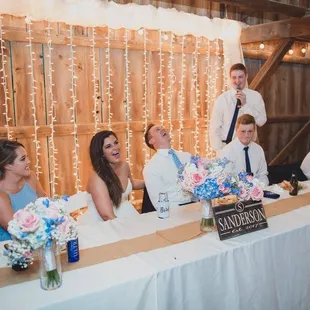 Toasting to the bride and groom at their wedding reception in the barn