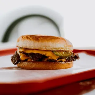 a cheeseburger on a red tray