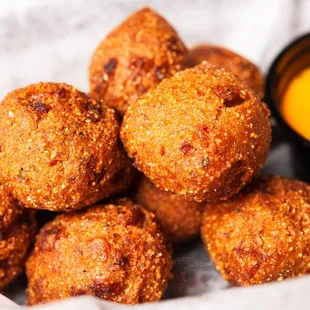 a pile of fried crab balls with dipping sauce