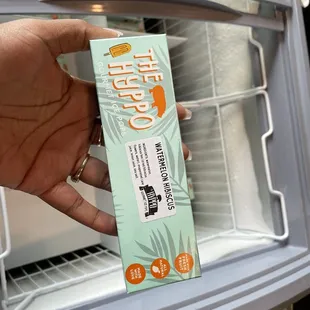a hand holding a package of yogurt