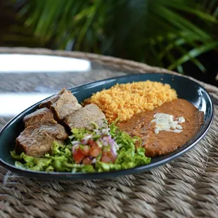 Carnitas - pork tips served with rice, beans, tomatillo sauce, lettuce, pico, &amp; warm tortillas