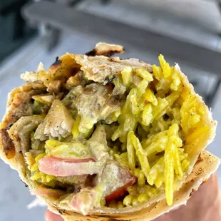 a hand holding a burrito