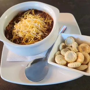 a bowl of chili and crackers