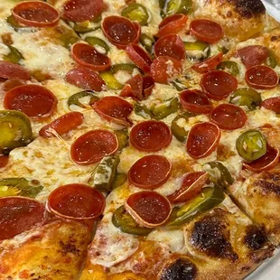 a pizza with pepperoni and jalapenos