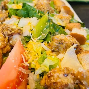 a salad with chicken, lettuce, tomatoes and cheese