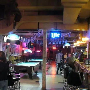 a bar with pool tables and neon lights