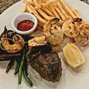 Steak and shrimp with fries.