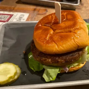 a hamburger and pickle on a plate