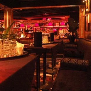 a dimly lit bar with tables and chairs