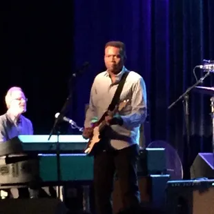 a man playing a guitar on stage
