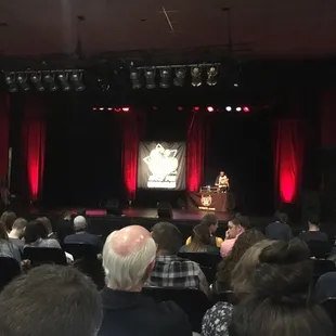 a man on a stage speaking to a crowd