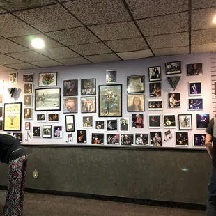 a man and a woman looking at pictures on the wall