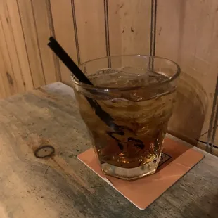 a glass of whiskey on a coaster