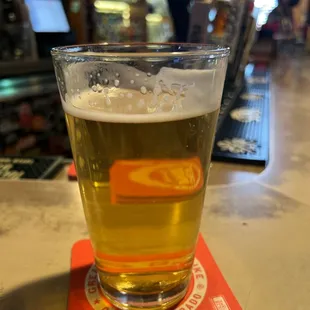 a glass of beer on a coaster