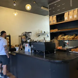 a man standing at a counter in a bakery