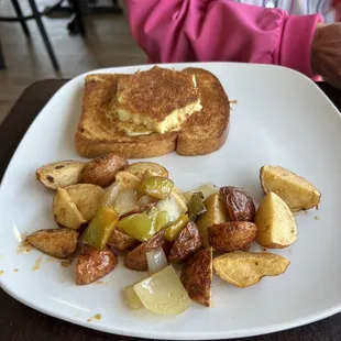 2 eggs in grilled brioche bread with side potatoes.