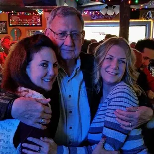 a man and two women hugging