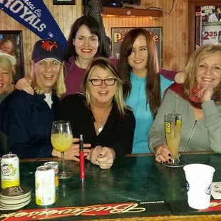 a group of women sitting at a bar