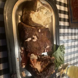 Rib and chicken combo plate with baked potato as side.