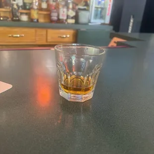 a glass of whiskey on a bar