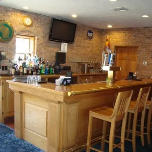 a bar with chairs and a television