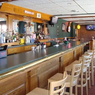 a bar with stools and a television