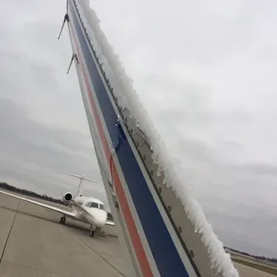 the tail of an airplane covered in snow