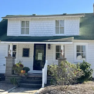 Front of "house" that is Kind Cup. Enter the shop on both sides. Small lot parking on rhs. In Historic Corolla Village - a must see