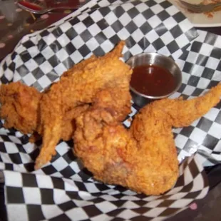 a basket of fried chicken with dipping sauce