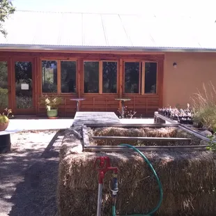 the outside of a house with hay bales
