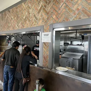 a group of people standing in line at the counter