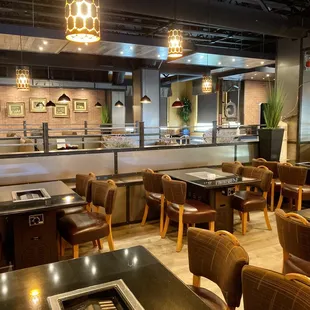 Clean, well-lit dining room with grill top tables