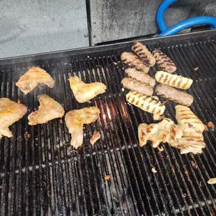 a variety of food being cooked on a grill
