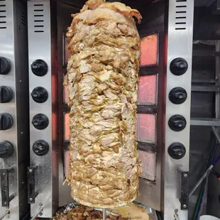 a large meat skewer being cooked