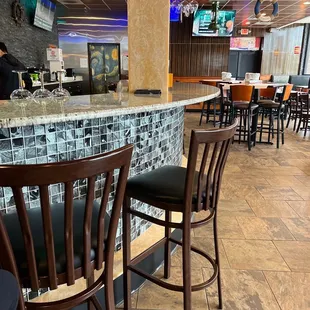 a restaurant with a bar and chairs