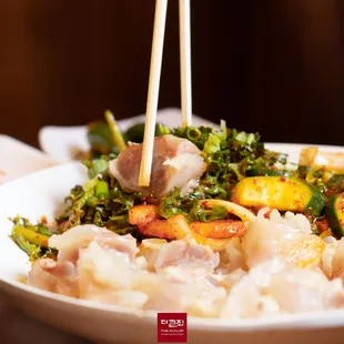 a bowl of food with chopsticks