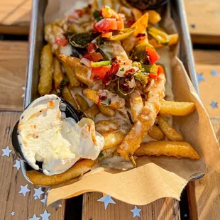 a tray of french fries with a side of dips