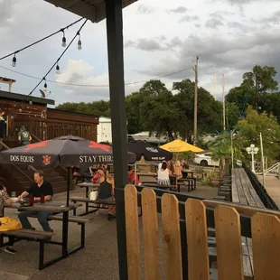 people sitting at tables under umbrellas