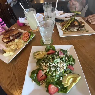 In front is the sunset strawberry salad. To the left was a BBQ chicken sandwich. Right is a ribeye with garlic potatoes and asparagus.
