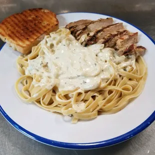 a plate of pasta with chicken and gravy