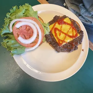 a burger with onion, tomato and lettuce