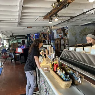 a woman standing at the counter of a restaurant