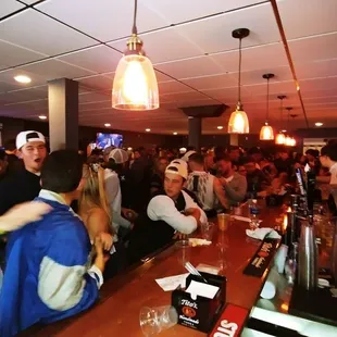 a large group of people sitting at the bar
