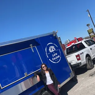 a woman leaning against a food truck
