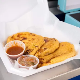 The pupusas served with curtido and salsa roja.